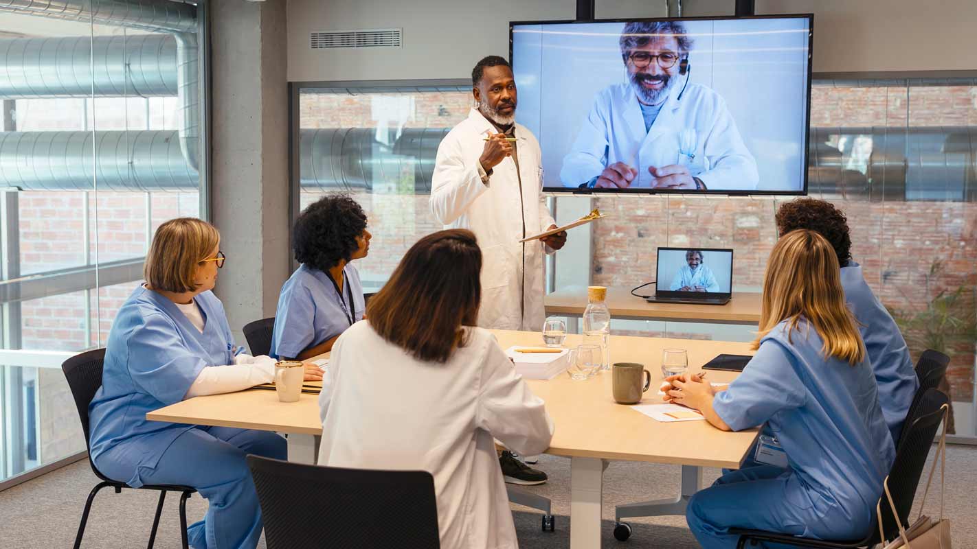 physician presenting to a medical team in a board room